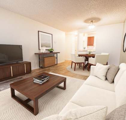 A living room with a white couch and a wooden coffee table.