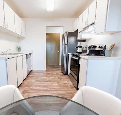 A modern kitchen with white cabinets and a black refrigerator.