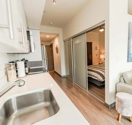 a kitchen and living room with a sliding glass door to a bedroom at Icon Apartments, Washington, 98104
