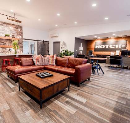 A living room with a brick wall and wooden flooring. at Notch 8, Tacoma, 98444