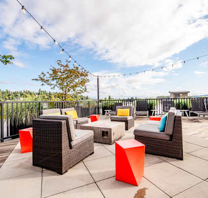 A patio with wicker furniture and orange accents. at The Platform, Kent, 98032
