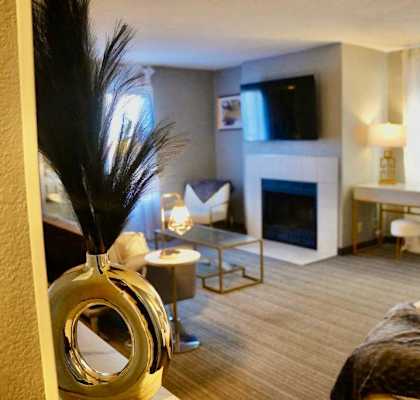 a bedroom with a bed and a living room with a fireplace