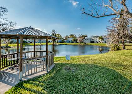 a gazebo with a sign in front of a lake