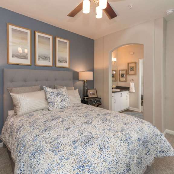 A blue and white bedroom with a bed and a ceiling fan at Artisan 8282.