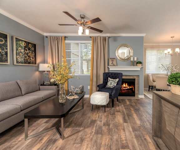 A living room with a couch, a chair, a fireplace, and a coffee table at Artisan 8282. 