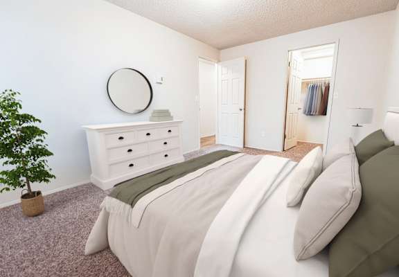 A bedroom with a bed, dresser, and mirror.