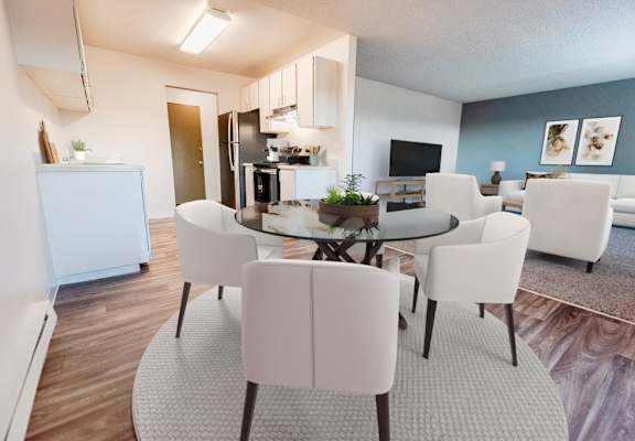 A modern dining room with a glass table surrounded by white chairs.