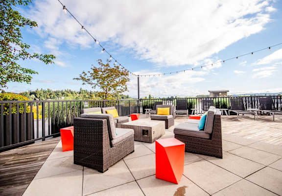 A patio with wicker furniture and a view of the sky.