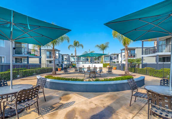 a courtyard with tables and chairs and umbrellas