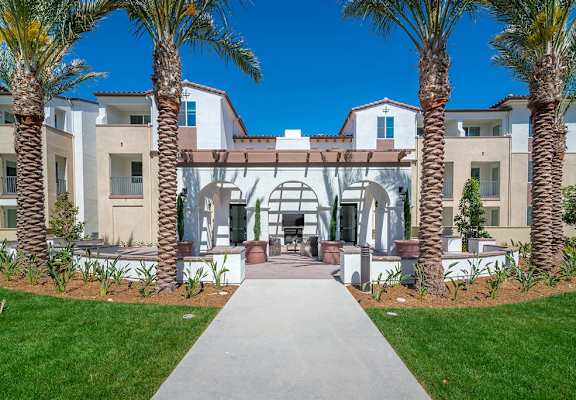 a mansion with palm trees in front of it