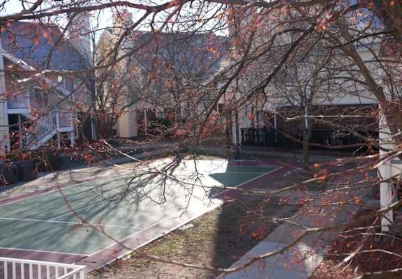 a tennis court in the backyard of a house