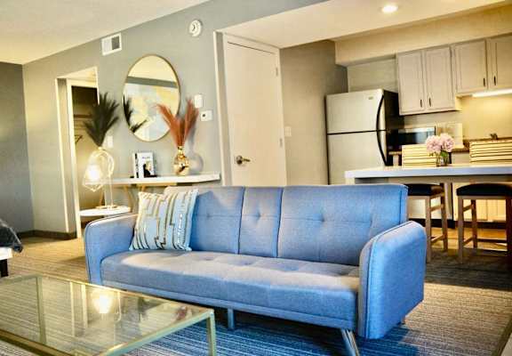 a living room with a blue couch and a table