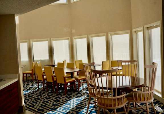 a dining room with wooden tables and chairs