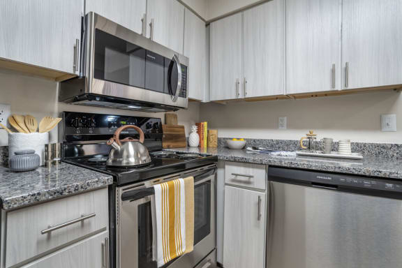 a kitchen with stainless steel appliances and granite countertops  at Elme Manassas in Manassas, VA