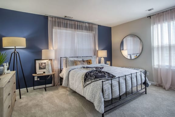 a bedroom with a bed and a blue accent wall  at Elme Manassas in Manassas, VA