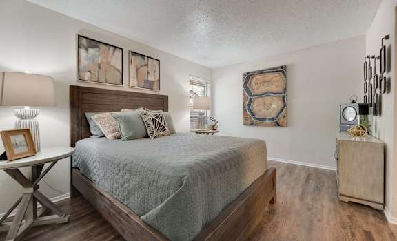 a bedroom with a bed and a dresser and a window