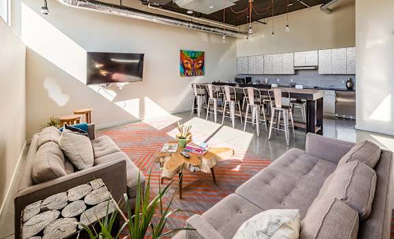 a living room with couches and chairs and a kitchen in the background at Cuvee, Seattle, 98122