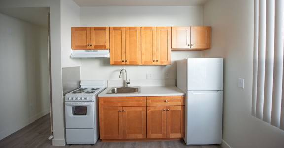 A kitchen with wooden cabinets and white appliances.