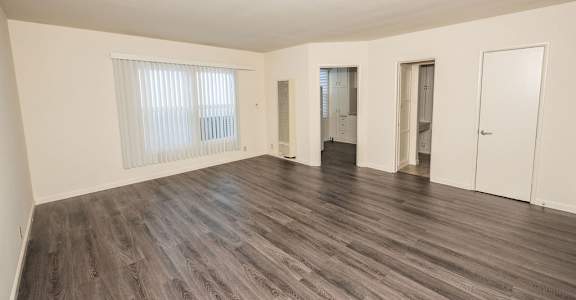A room with wooden flooring and white walls.