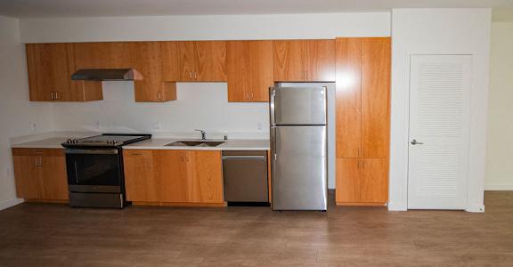 A kitchen with wooden cabinets and a stainless steel refrigerator.