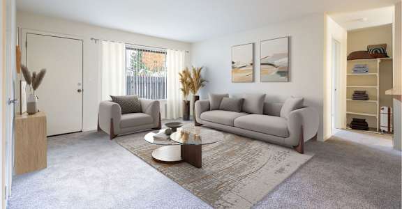 A living room with a grey sofa, a coffee table, and a rug at Cherrywood Apartments, San Jose, California