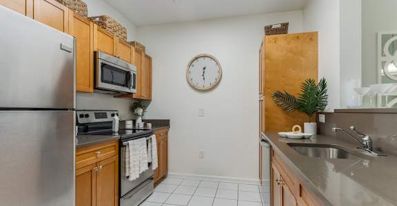 A kitchen with a refrigerator, microwave, and oven.