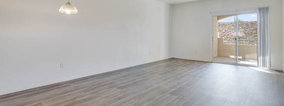 A room with a wooden floor and a hanging light fixture.