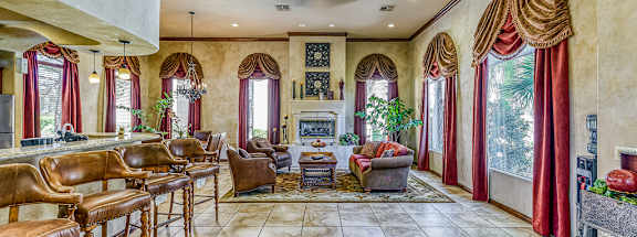 a large living room with a bar and a fireplace