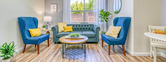 A living room with blue chairs and a green couch.