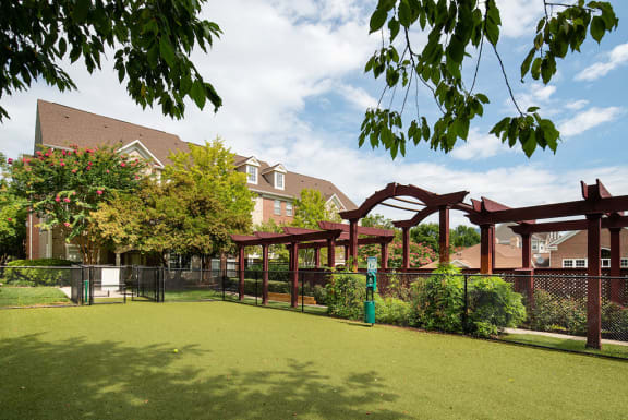 a green lawn with a swing set in front of a building at Woodland Park, Herndon, Virginia