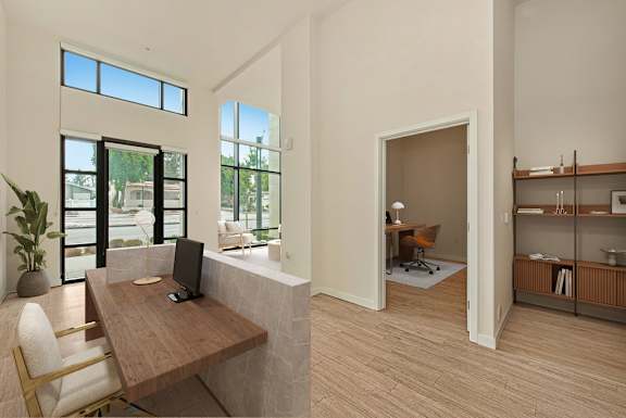 A room with a desk and chairs with a window and a doorway leading to another room.