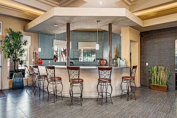 a bar in the lobby of a hotel with bar stools
