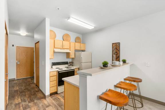 A kitchen with wooden floors and furniture.at Fifth Avenue Place Apartments, Oregon