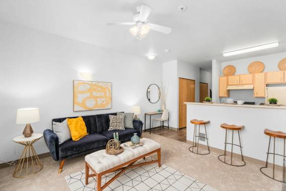 A living room with a blue couch and a painting on the wall.at Fifth Avenue Place Apartments, Oregon
