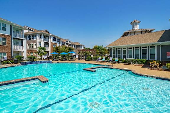 a large swimming pool with an apartment building in the background