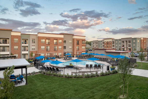 pool with cabanas and green space surrounded by apartments