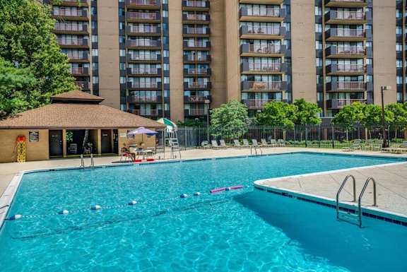 a swimming pool with an apartment building in the background