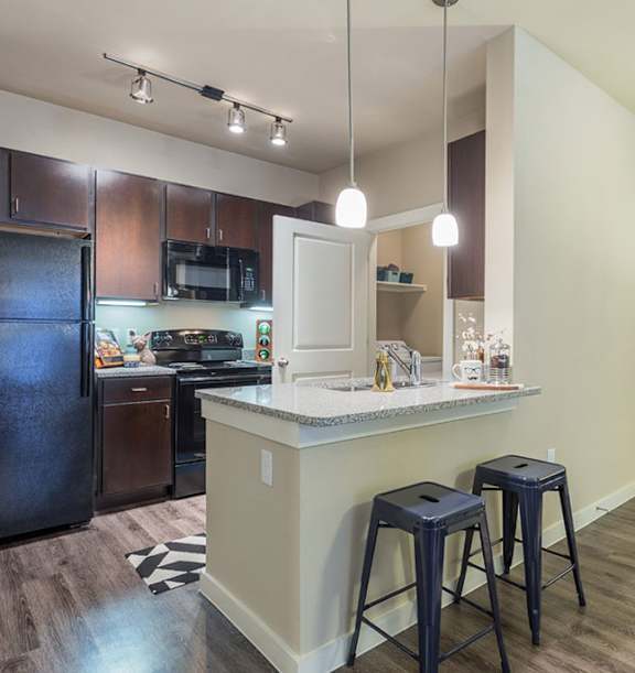 A kitchen with a black fridge and a white door.