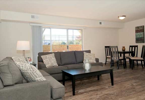 A living room with a grey couch, a black coffee table, and a lamp.