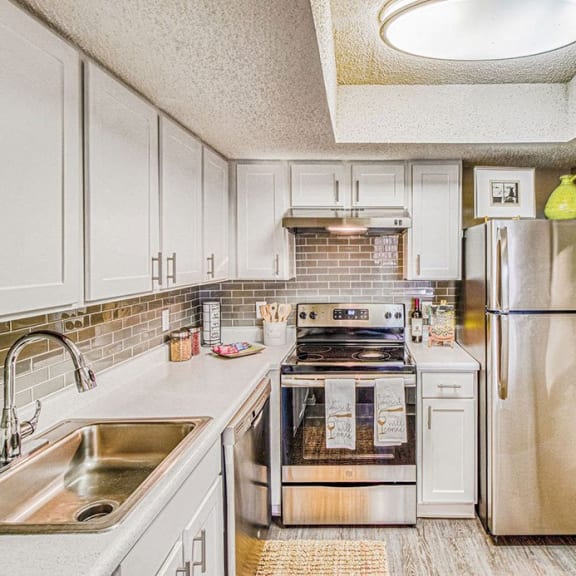 kitchen with white cabinets and a fridge at Hillside Creek in Austin, TX