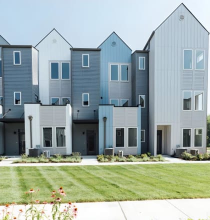 a row of townhomes with a grassy yard