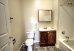 Bathroom with wooden cabinets and grey patterned tile floors