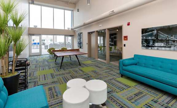 A room with a blue couch and a green plant.at City Square Lofts, Des Moines, 50309