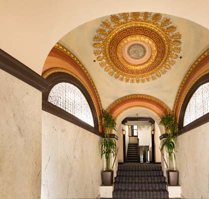 the lobby of a building with an ornate ceiling and stairs  at The Mount Royal, Baltimore, MD, 21202
