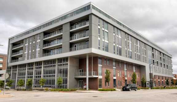 A large, modern building with a parking lot in front.at City Square Lofts, Des Moines, IA 50309
