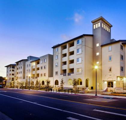 a street view of a large apartment building with street lights