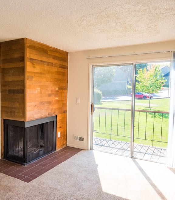 Todd Village vacant home with wood burning fireplace and sliding glass door to deck at Todd Village Apartments, Tualatin, Oregon 97062