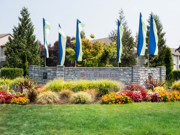 Sir Charles Court property entrance monument sign, flags, and flowers 