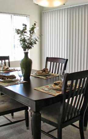 A kitchen with a black oven and wooden cabinets.