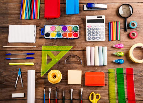 an assortment of art supplies and tools on a wooden table